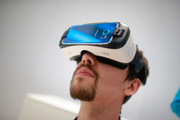 A visitor wears a Samsung Gear VR virtual reality headset in the Samsung Electronics Co. pavilion at the Mobile World Congress in Barcelona, Spain, on Tuesday, March 3, 2015. The event, which generates several hundred million euros in revenue for the city of Barcelona each year, also means the world for a week turns its attention back to Europe for the latest in technology, despite a lagging ecosystem. Photographer: Pau Barrena/Bloomberg via Getty Images